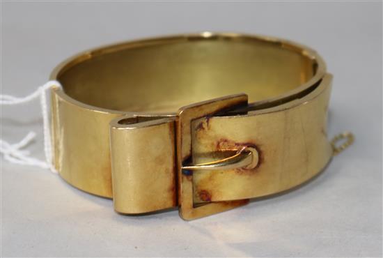 An early 20th century yellow metal buckle design hinged bangle.